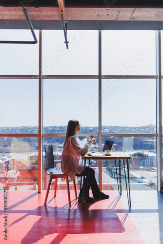 Businesswoman manager in a white shirt doing office work and smiling, successful european female boss in optical glasses for vision correction, posing at a table in a workspace