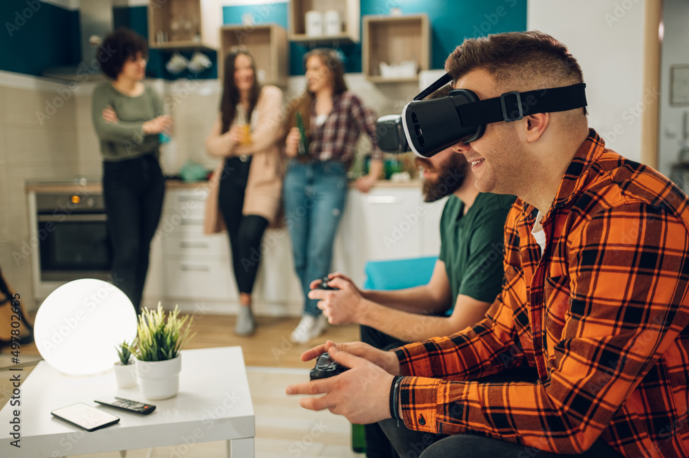 Male friends playing video games on a virtual reality glasses at home