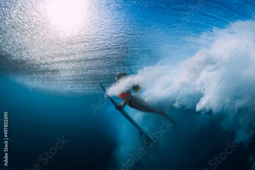 Canvas Print Surfer girl with surfboard dive underwater with big ocean wave at ocean