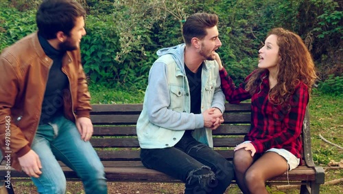 young man talking to a young woman is excluded when a mutula friend arrives