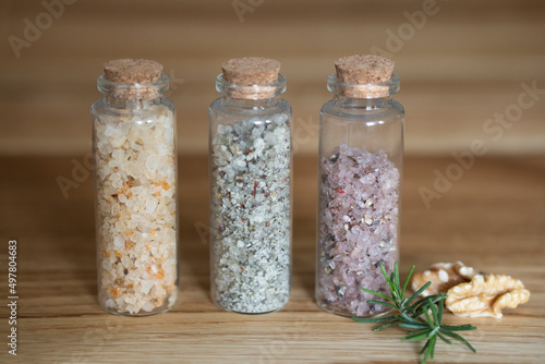Postcard Set of glass bottles with multi-colored kitchen salt with spices rosemary nuts and purple wine salt. With craft label layout for text