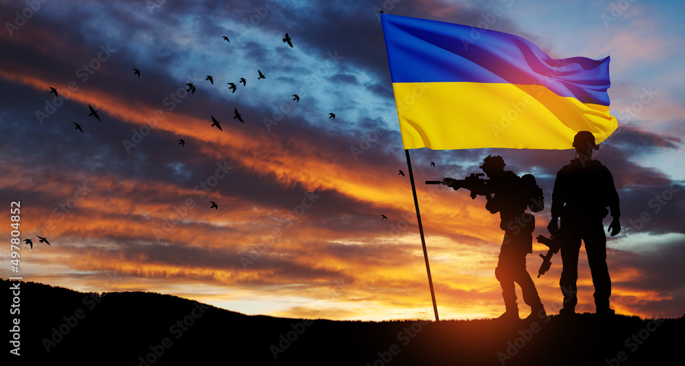 Flag of Ukraine with silhouette of soldier against the sunrise or ...