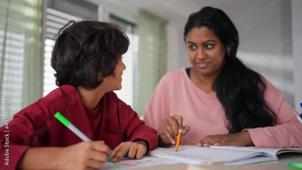 Little multiracial boy doing homework with his mother at home. Little multiracial boy doing homework with his mother at home.
