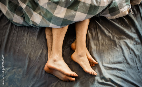 legs of couple in bed making love photo