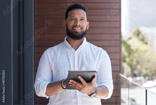 You just have to be confident in what you do. Portrait of a young businessman using a digital tablet outside an office.