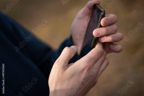 Smartphone in hand. The guy is on the phone. Communication device. Search for information.