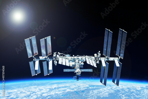 Fototapeta Naklejka Na Ścianę i Meble -  ISS over the planet, against the background of clouds. Elements of this image furnished by NASA