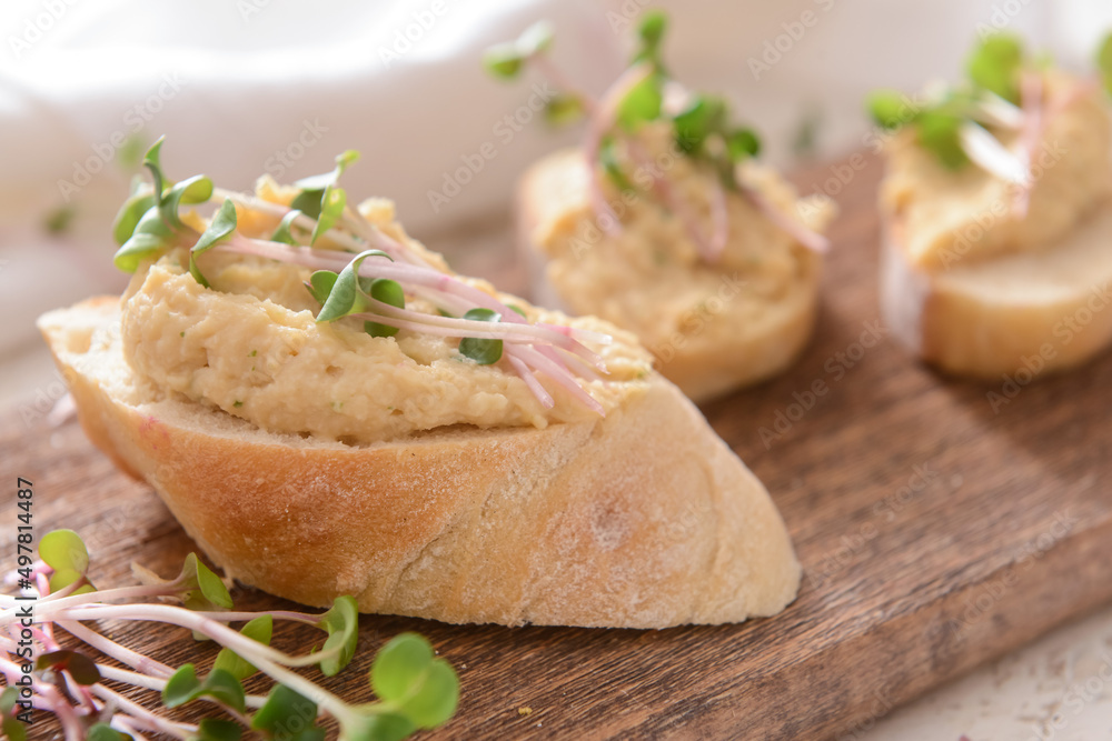 Board with piece of bread and tasty hummus, closeup Board with piece of bread and tasty hummus, closeup