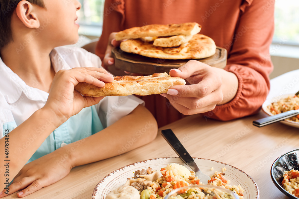 Muslim little boy with his mother having breakfast together. Celebration of Eid al-Fitr Muslim little boy with his mother having breakfast together. Celebration of Eid al-Fitr