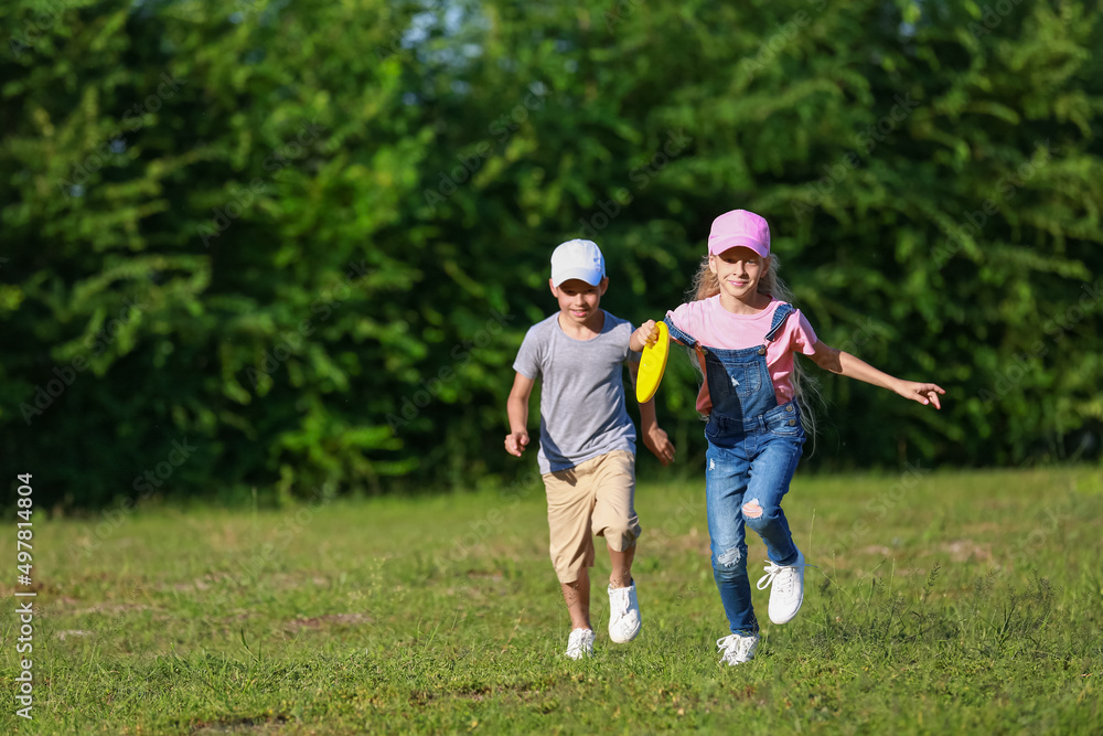 Cute little children playing frisbee outdoors