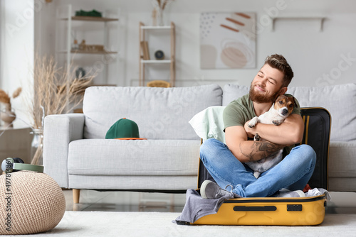 Young man with cute dog sit...