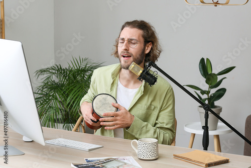 Young man with drum singing...