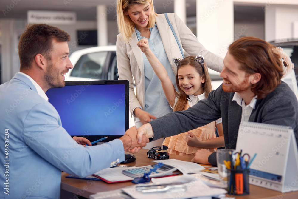 Obraz premium family buying a new car in city dealership and talking with salesman