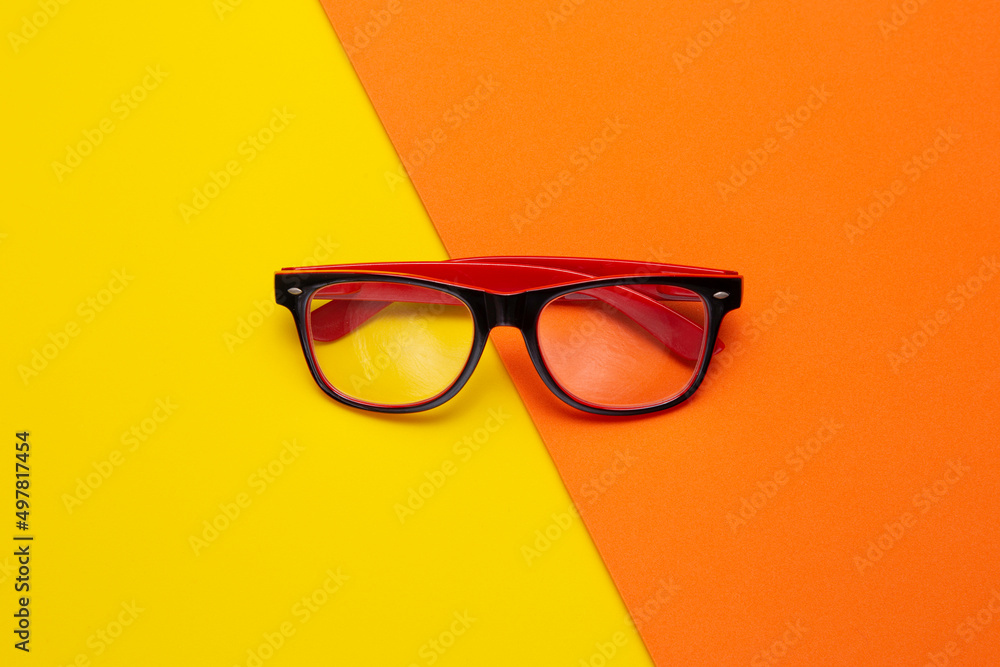 Stylish shaped glasses on color background, top view Stylish shaped glasses on color background, top view