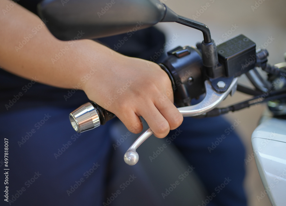 Closeup boy clutching motorcycle brake for safety