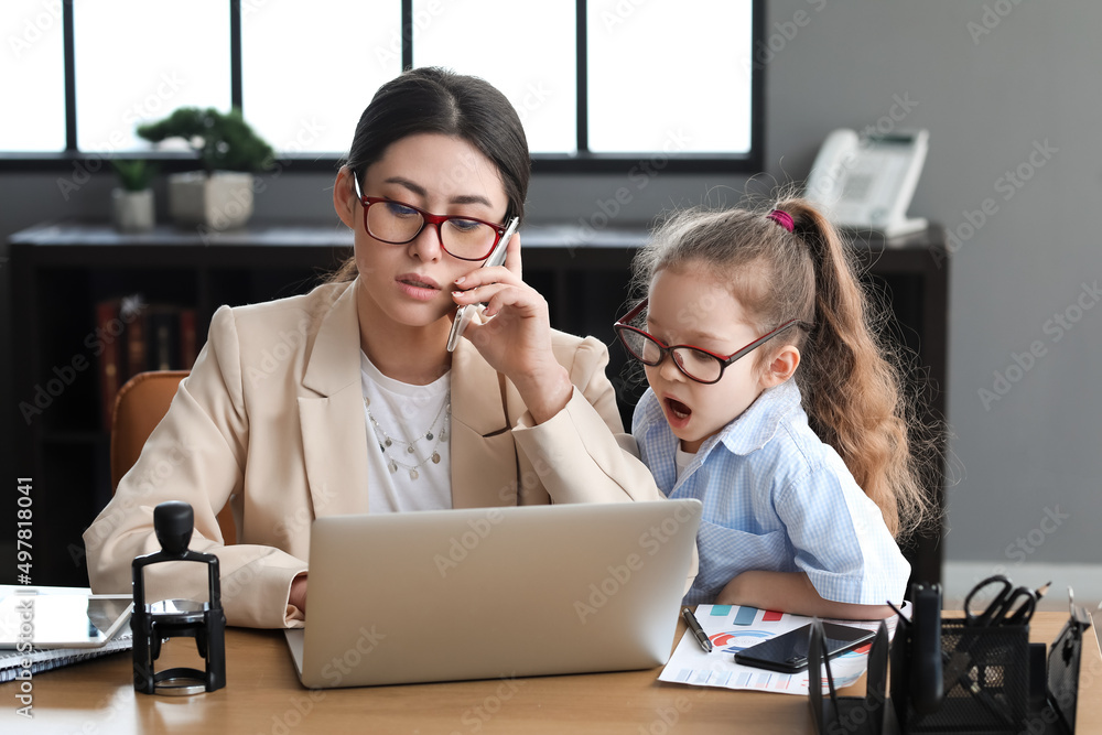 Little daughter keeping mother from her work in office Little daughter keeping mother from her work in office