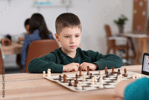 Little boy playing chess du...
