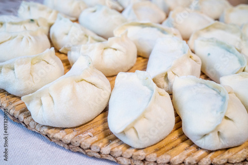 Raw Chinese dumplings on the reed plate ready for steaming