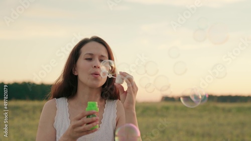 woman blowing soap bubbles park. festive mood. women outdoor recreation. happy woman vacation travel. beautiful transparent balloons outdoors. fun relaxing fun game play. holiday entertainment dream