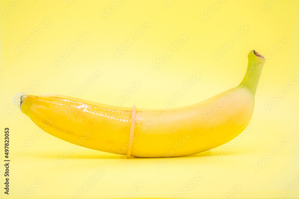 Transparent condom placed on banana. concpt of sexual protection Transparent condom placed on banana. concpt of sexual protection