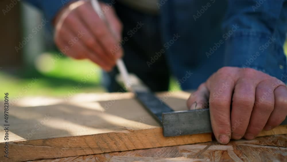 Close-up of handyman measuring a board, outside in garden. Close-up of handyman measuring a board, outside in garden.