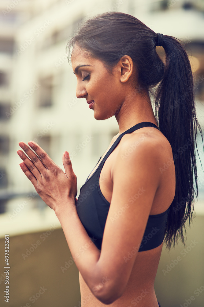 Learn to unite your body and mind. Shot of a beautiful young woman practising yoga outdoors.
