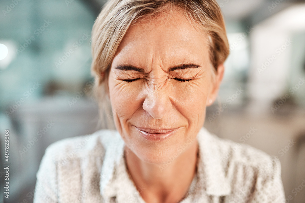 Dealing with a bit of tension. Shot of a mature woman closing her eyes in pain.