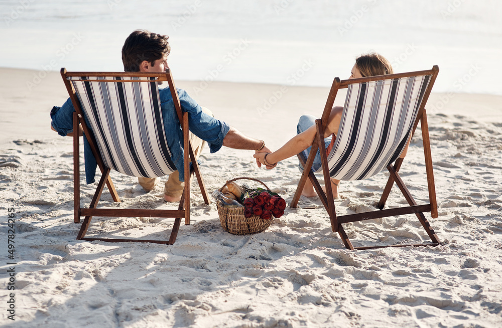 Here for the ocean waves and lazy days. Rearview shot of a middle aged couple sitting in their beach chairs on the the beach.