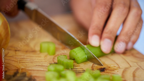 The base of every soup. Shot of a woman chopping up celery.