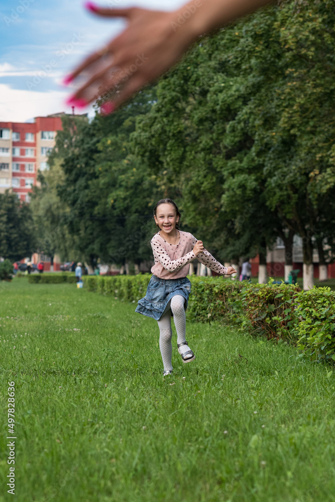 Little cheerful girl running through the grass. Little cheerful girl running through the grass.