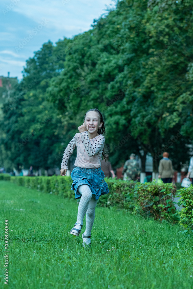 Little cheerful girl running through the grass. Little cheerful girl running through the grass.