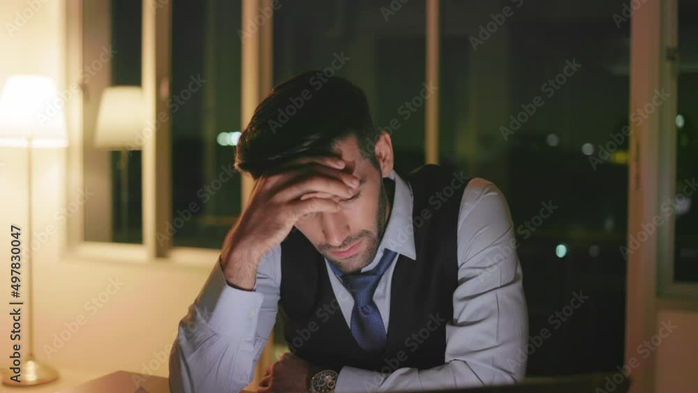 Caucasian businessman working on a laptop late night in the office Caucasian businessman working on a laptop late night in the office