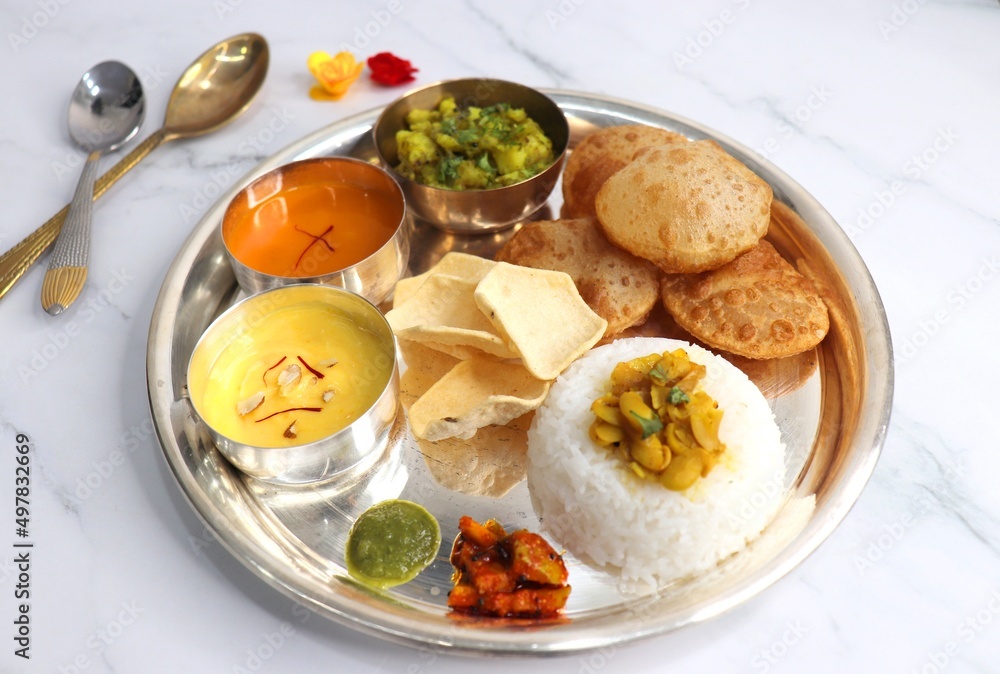 Indian vegetarian lunch or dinner Thali includes Aloo ki sabji, dal rice, Puri bhaji, Shrikhand or Srikhand, Aamras, papad, pickle, and chutney. Indian food is served in a Silverplate or thali. copy. Indian vegetarian lunch or dinner Thali includes Aloo ki sabji, dal rice, Puri bhaji, Shrikhand or Srikhand, Aamras, papad, pickle, and chutney. Indian food is served in a Silverplate or thali. copy.