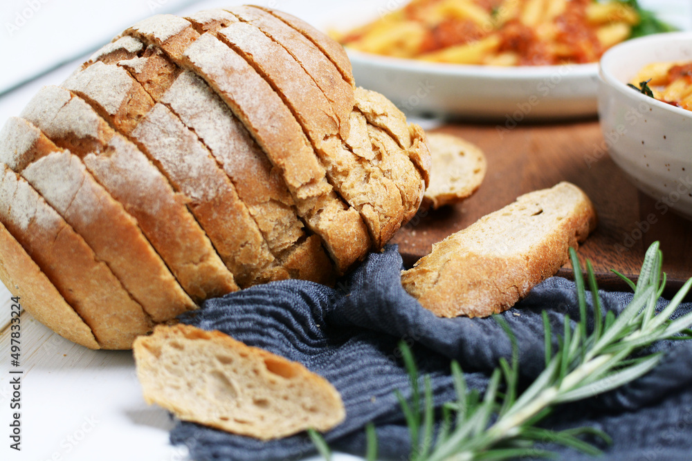 Closeup sliced bread with pasta background.