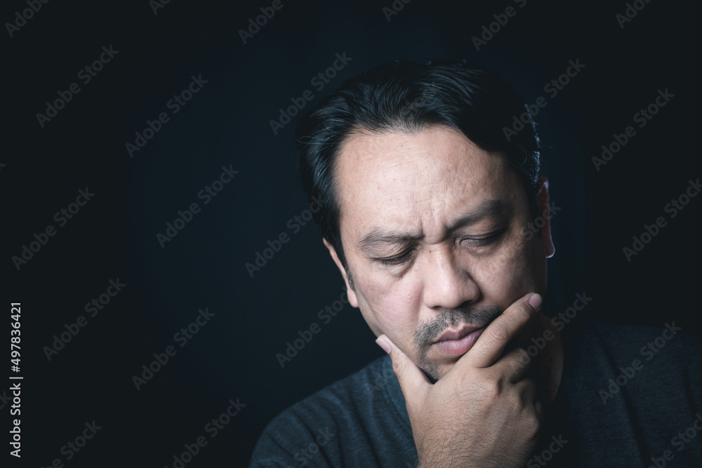 Asian middle age man thinking or serious isolated on black