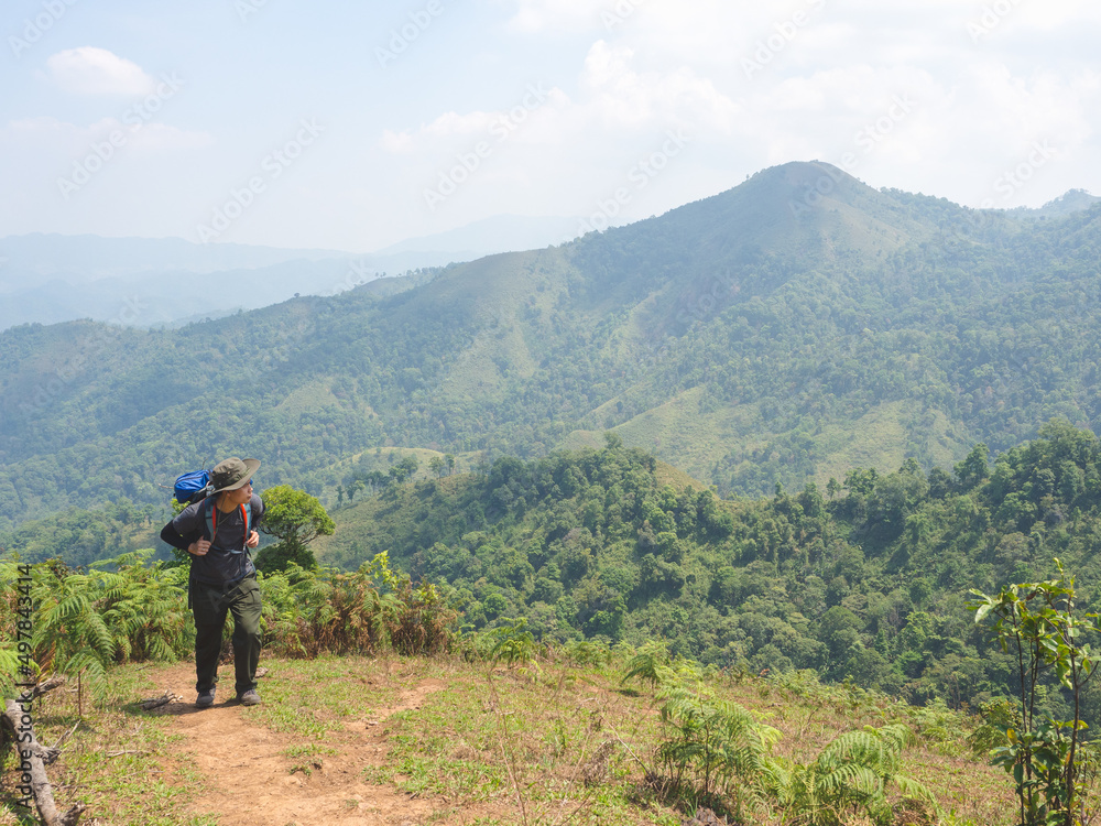 Obraz premium Trekking solo backpack on mountain trail in tropical forest at Tak Province, Thailand.