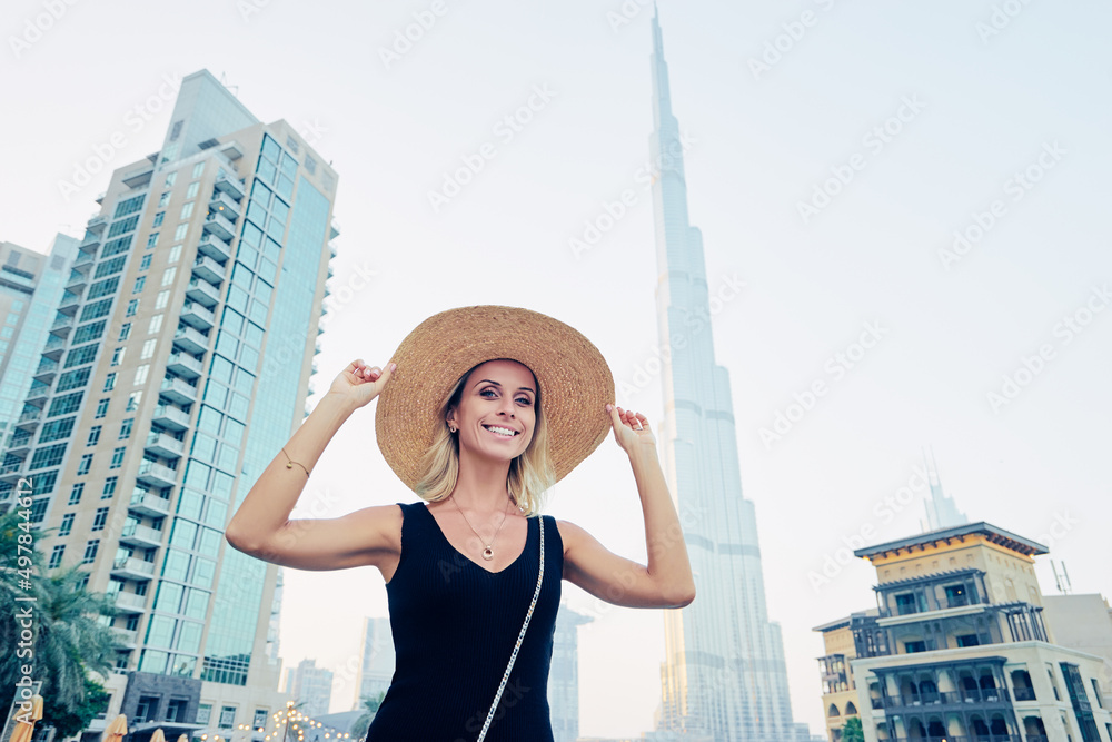 Young travelling woman in hat enjoying the view of Dubai downtown.
