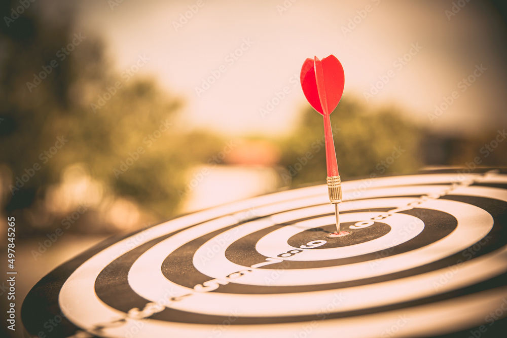 Bullseye or Bulls eye target or dartboard has dart arrow throw hitting the center of a shooting for financial business targeting planning and aim to winner goal of business concept. Bullseye or Bulls eye target or dartboard has dart arrow throw hitting the center of a shooting for financial business targeting planning and aim to winner goal of business concept.