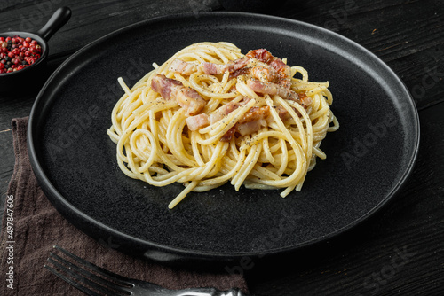 Carbonara pasta dish. Traditional Roman cuisine. Italian food, on black wooden background