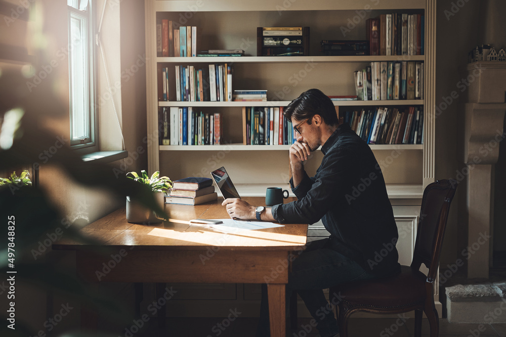 Giving this some careful thought. Shot of a young businessman looking thoughtful while working on a laptop in his office at home. Giving this some careful thought. Shot of a young businessman looking thoughtful while working on a laptop in his office at home.