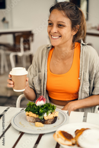 Young beautiful woman drinks coffee in a cafe and has breakfast with healthy food in a cafe.