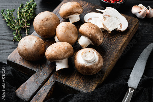 Brown champignons mushroom, on black wooden table background