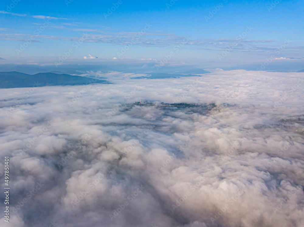 High flight above the clouds in the mountains. Aerial drone view.