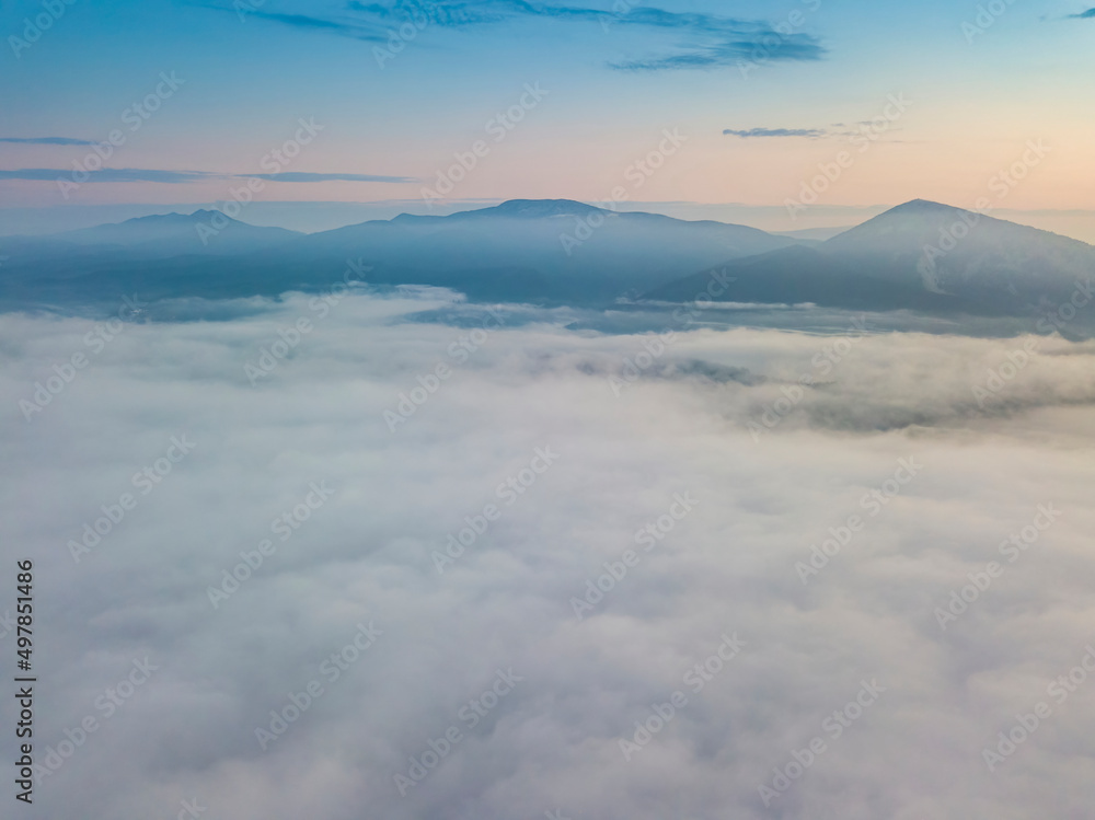 The rays of dawn over the fog in the Ukrainian Carpathians. Aerial drone view. The rays of dawn over the fog in the Ukrainian Carpathians. Aerial drone view.