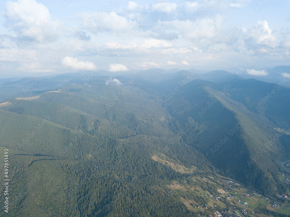 Green slopes of Ukrainian Carpathian mountains in summer. Cloudy day, low clouds. Aerial drone view. Green slopes of Ukrainian Carpathian mountains in summer. Cloudy day, low clouds. Aerial drone view.
