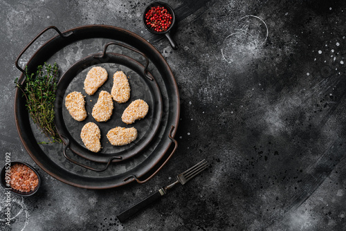Chicken nuggets uncooked set, on black dark stone table background, top view flat lay, with copy space for text