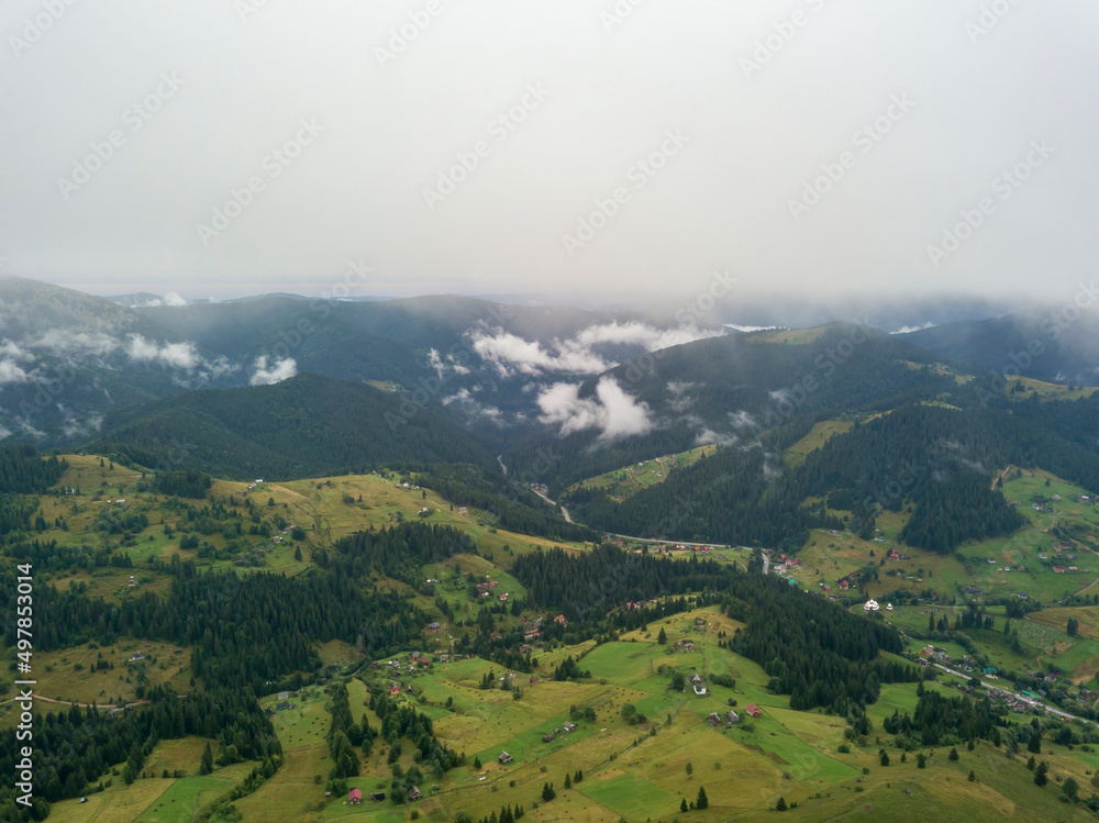Green slopes of Ukrainian Carpathian mountains in summer. Cloudy morning, low clouds. Aerial drone view. Green slopes of Ukrainian Carpathian mountains in summer. Cloudy morning, low clouds. Aerial drone view.