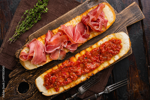 Spanish tomato and jamon toast set, on old dark  wooden table background, top view flat lay