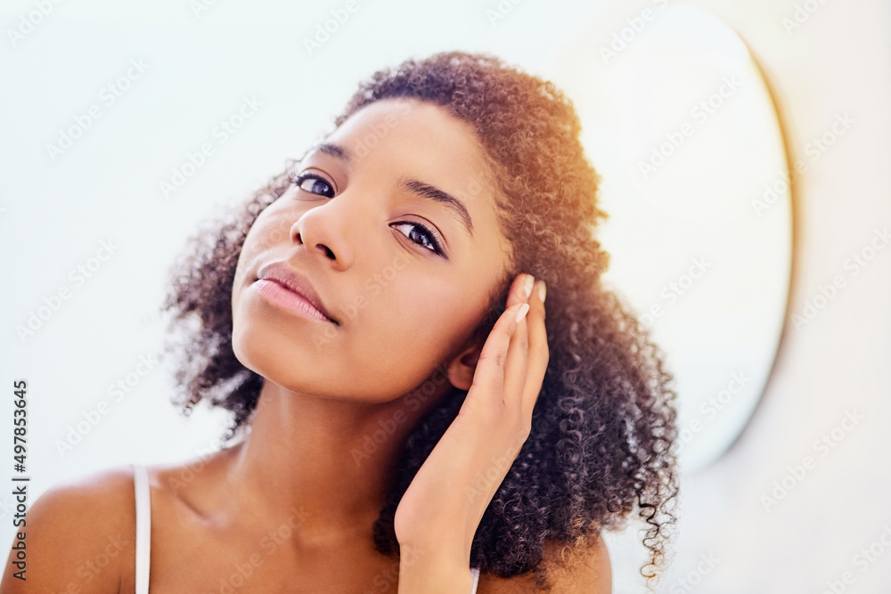 Make every morning a beautiful one. Shot of an attractive young woman admiring her face in the bathroom mirror. Make every morning a beautiful one. Shot of an attractive young woman admiring her face in the bathroom mirror.