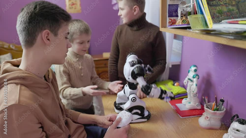 older brother explains to younger brothers how to play with robots ...